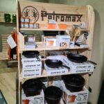 Petromax-Regal mit Gusseisenpfannen und Kochutensilien.